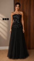 Front view of black strapless appliqué evening gown with pleated floor-length skirt